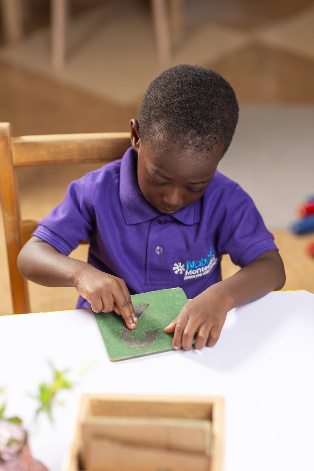 Child tracing a sandpaper letter