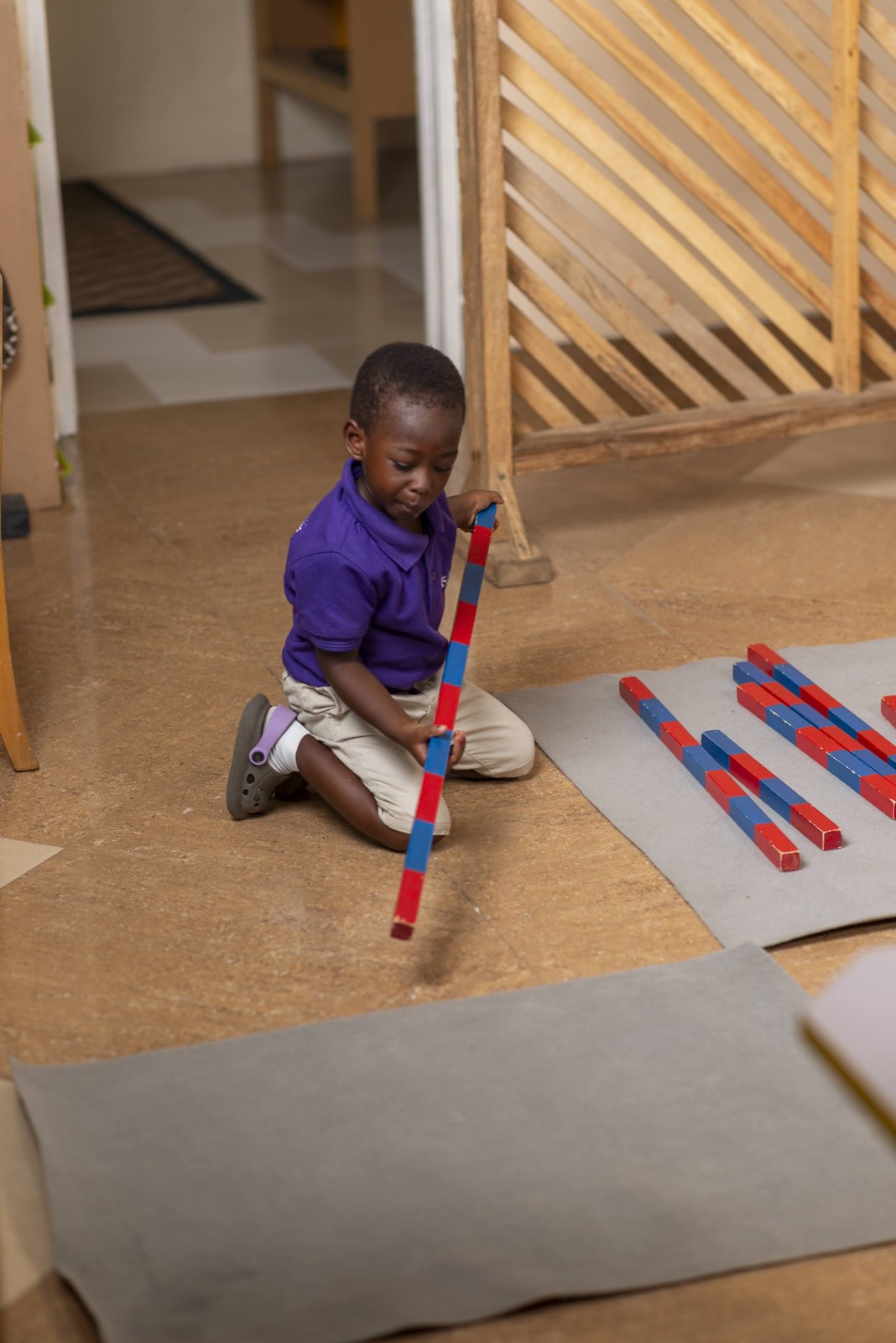 A Two's class child working with the number rods